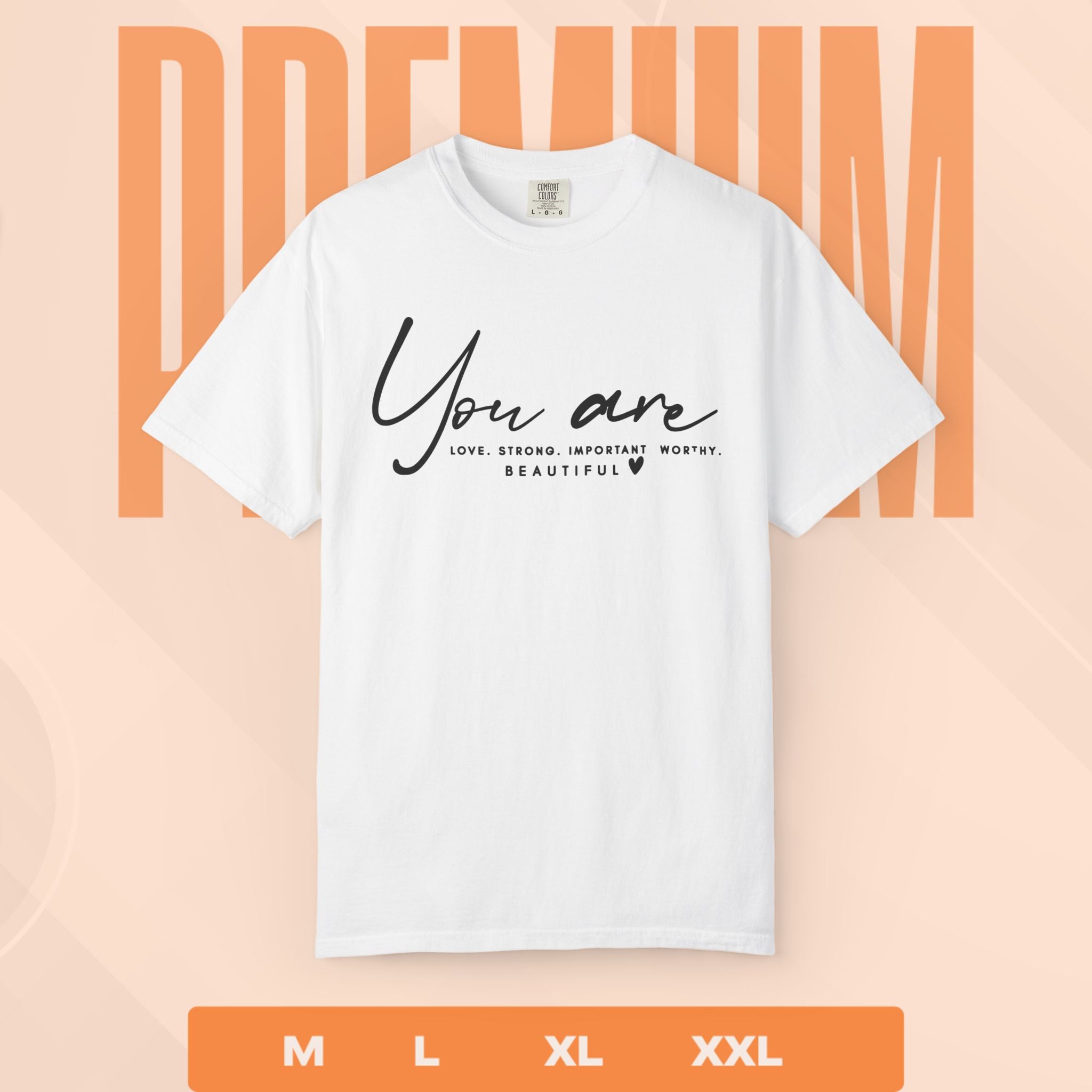 White t-shirt with motivational text on a peach background