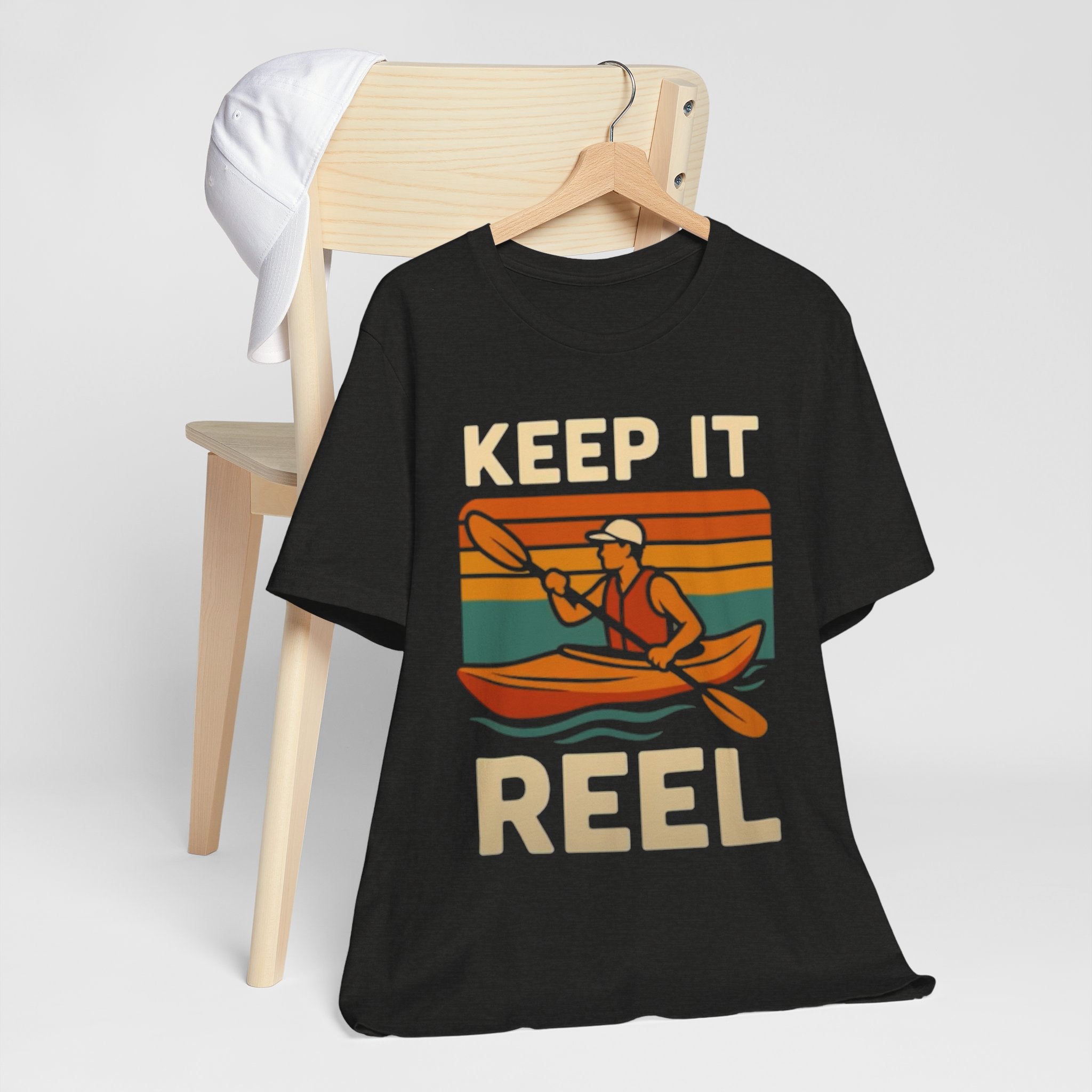 Black t-shirt with 'Keep It Reel' graphic design on a hanger against a white background