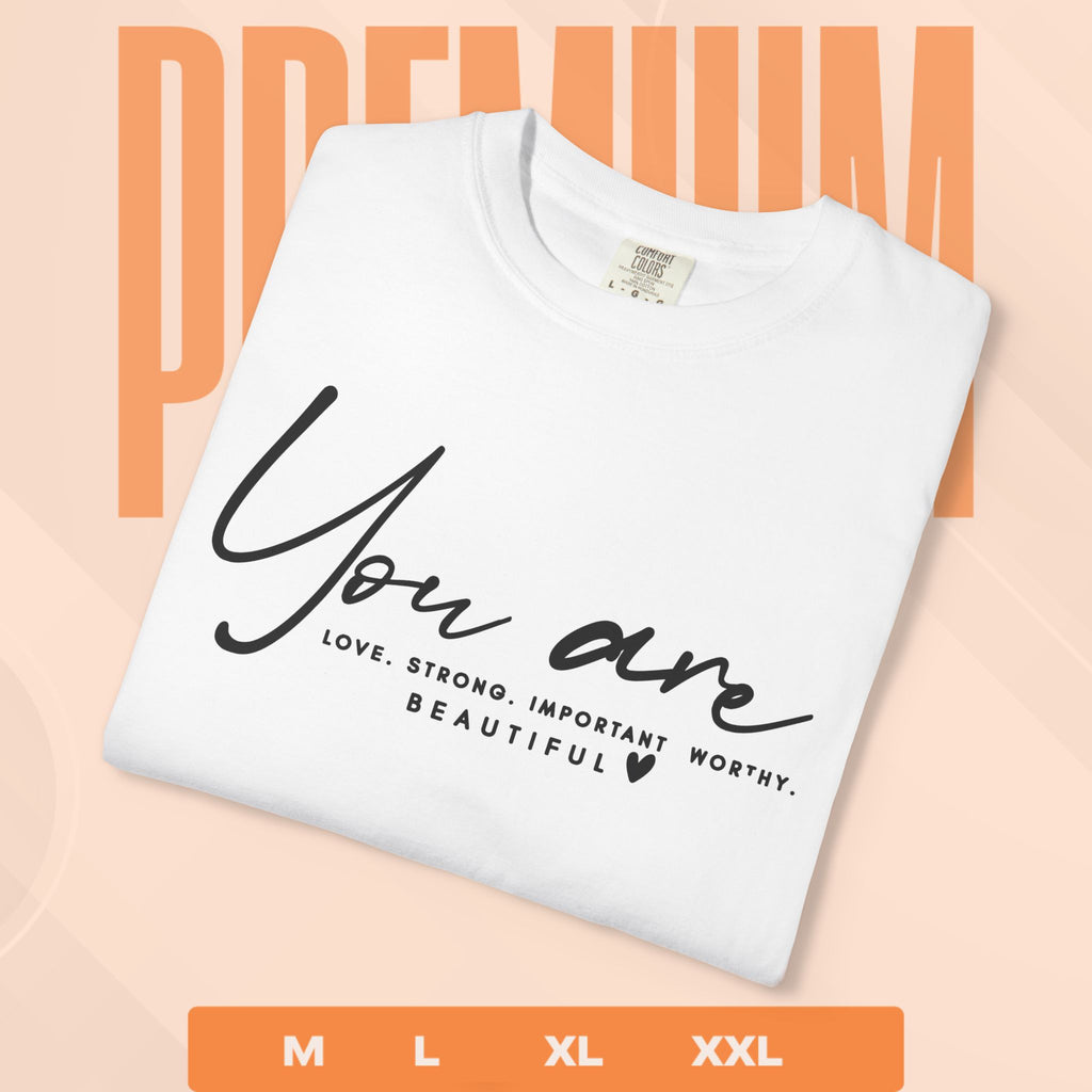 White t-shirt with motivational text on a peach background
