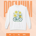 White sweatshirt with bicycle and flower design on a peach background
