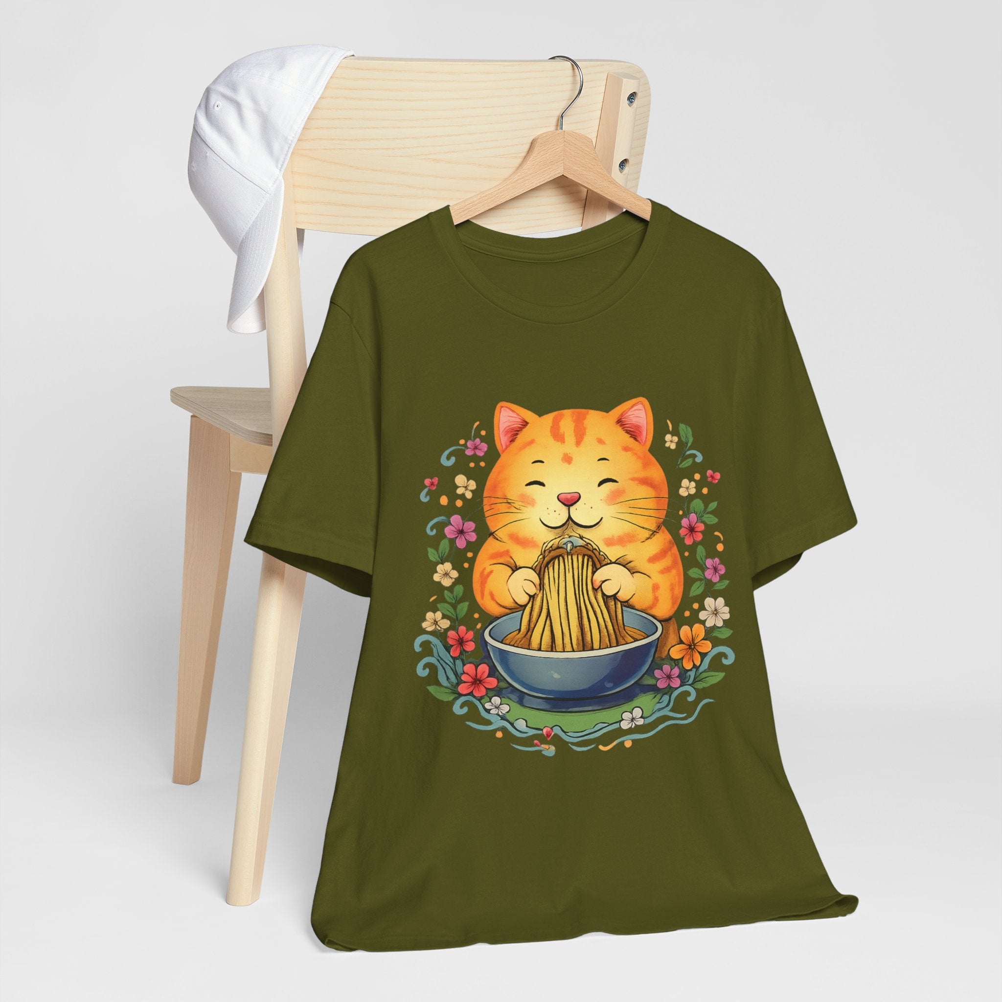 Green t-shirt with a cat eating noodles design on a white background