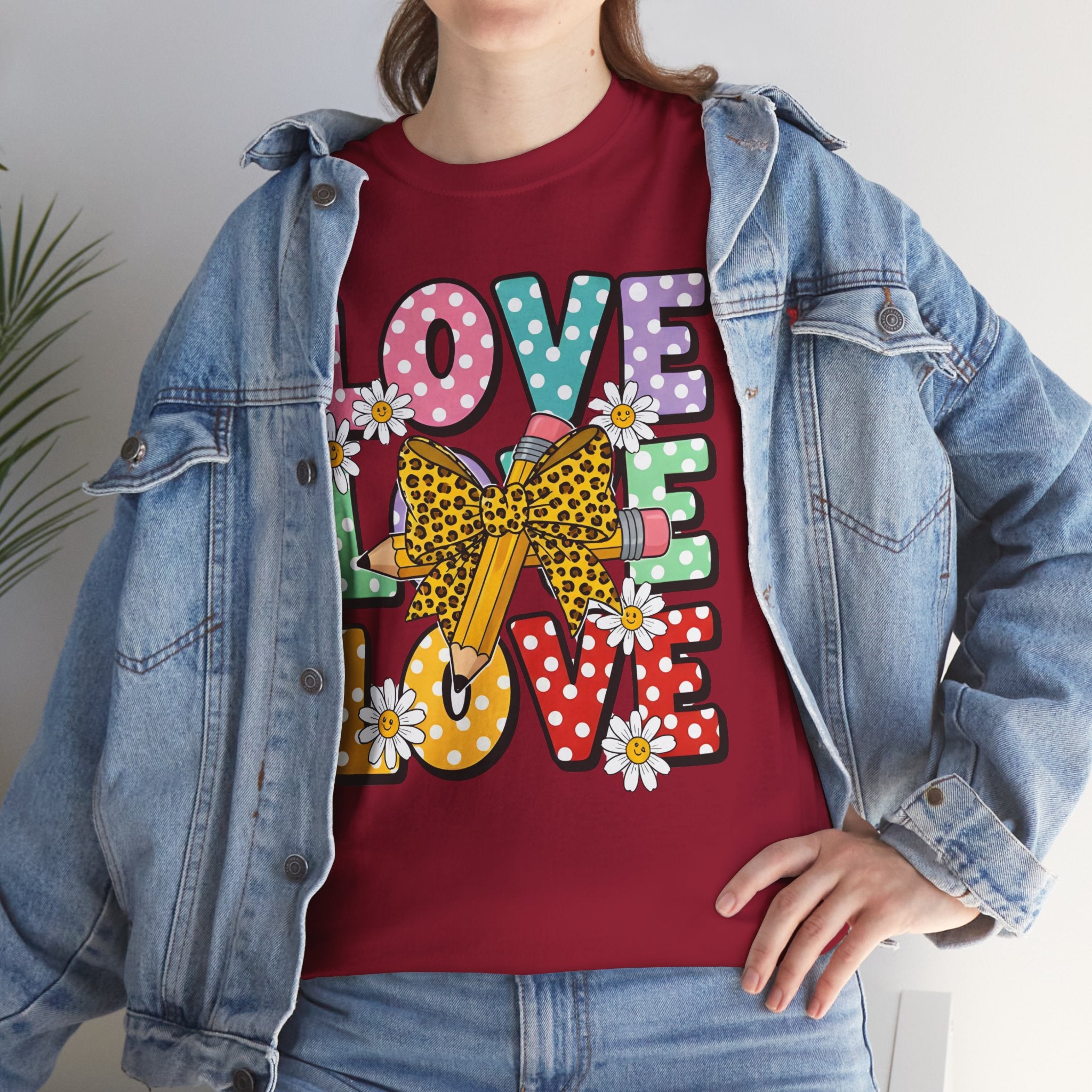 Person wearing a red t-shirt with colorful 'LOVE' design and denim jacket.