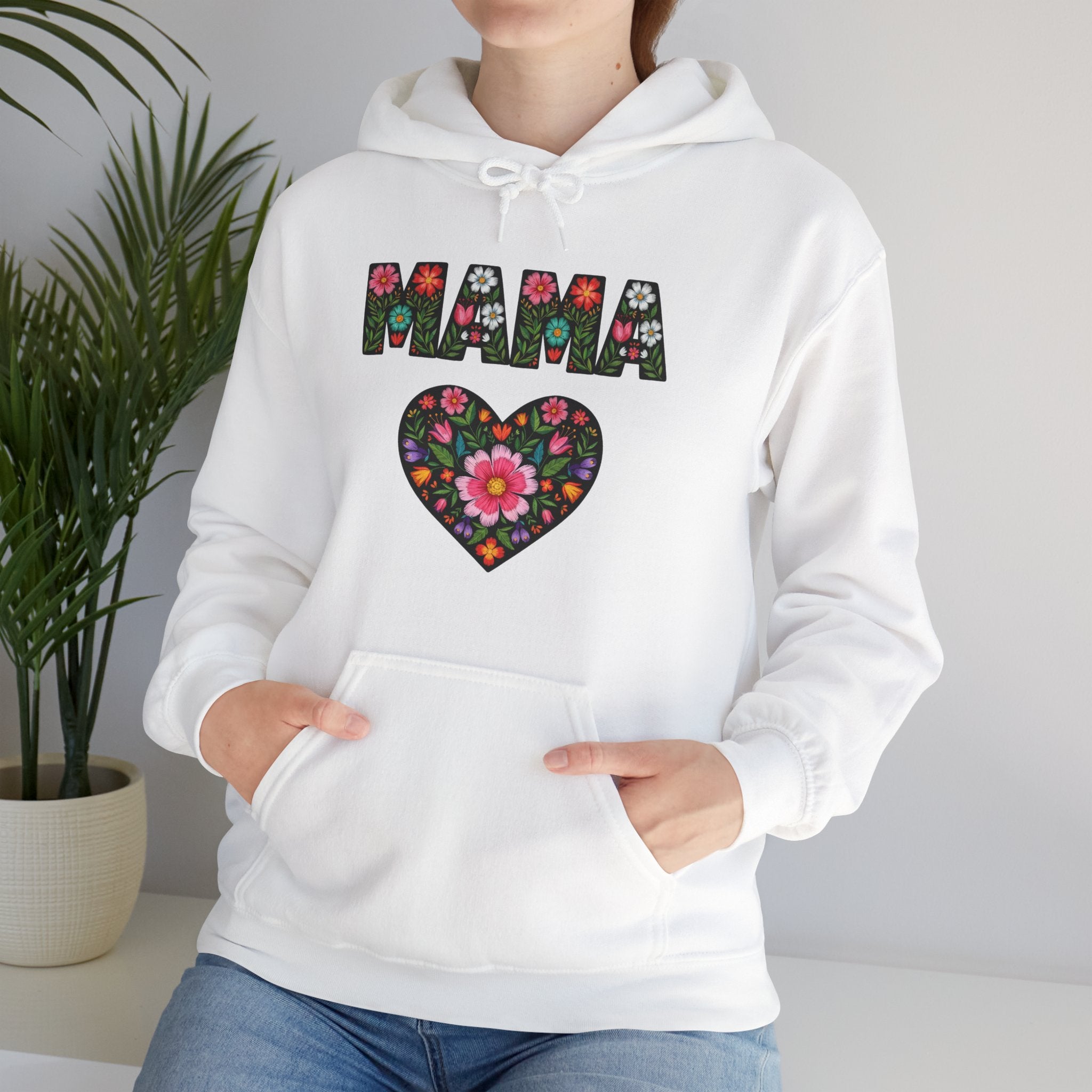 White hoodie with floral heart and 'MAMA' text design, worn by a person.