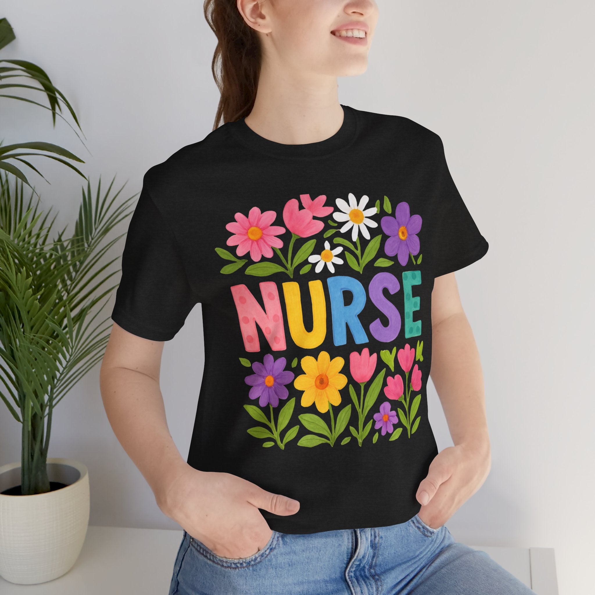 Person wearing a black t-shirt with colorful floral design and the word 'NURSE'.