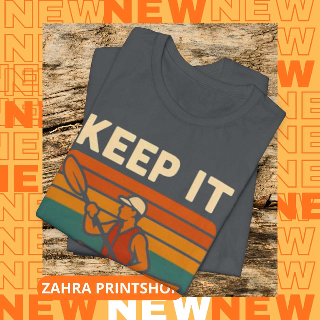 Folded gray t-shirt with 'KEEP IT' graphic on a wooden surface with 'NEW' text overlay.