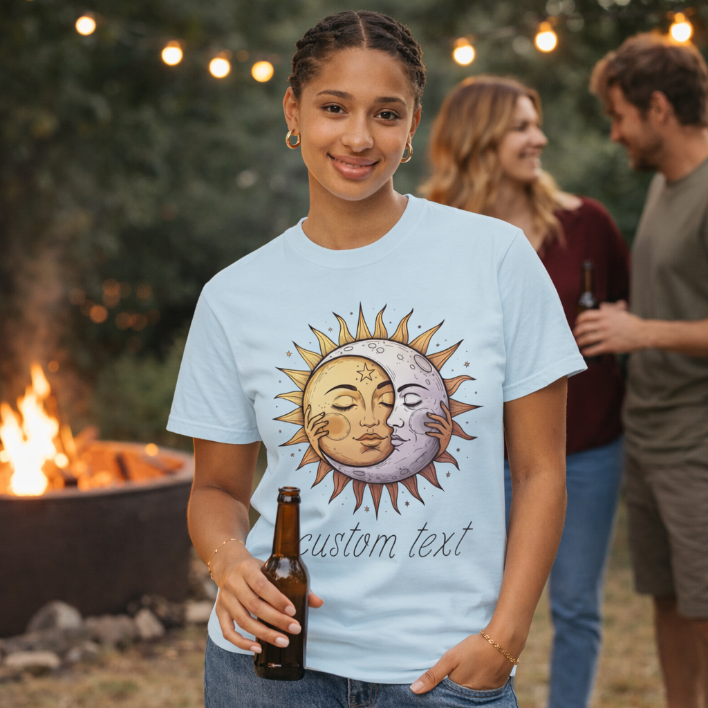 Person wearing a t-shirt with a sun and moon design, holding a beer, with a campfire and people in the background.